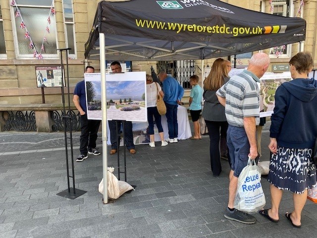 people stood under a cover looking at design proposal for a town centre regeneration