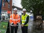 2 men wearing orange and yellow hi-vis jackets and hard hats at a demolition site