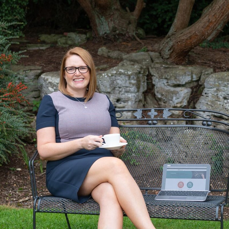 Woman sat on bench in front of wall