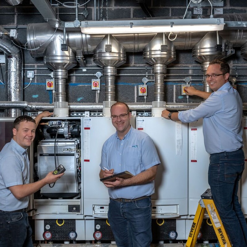 3 men in front of industrial electrical controls