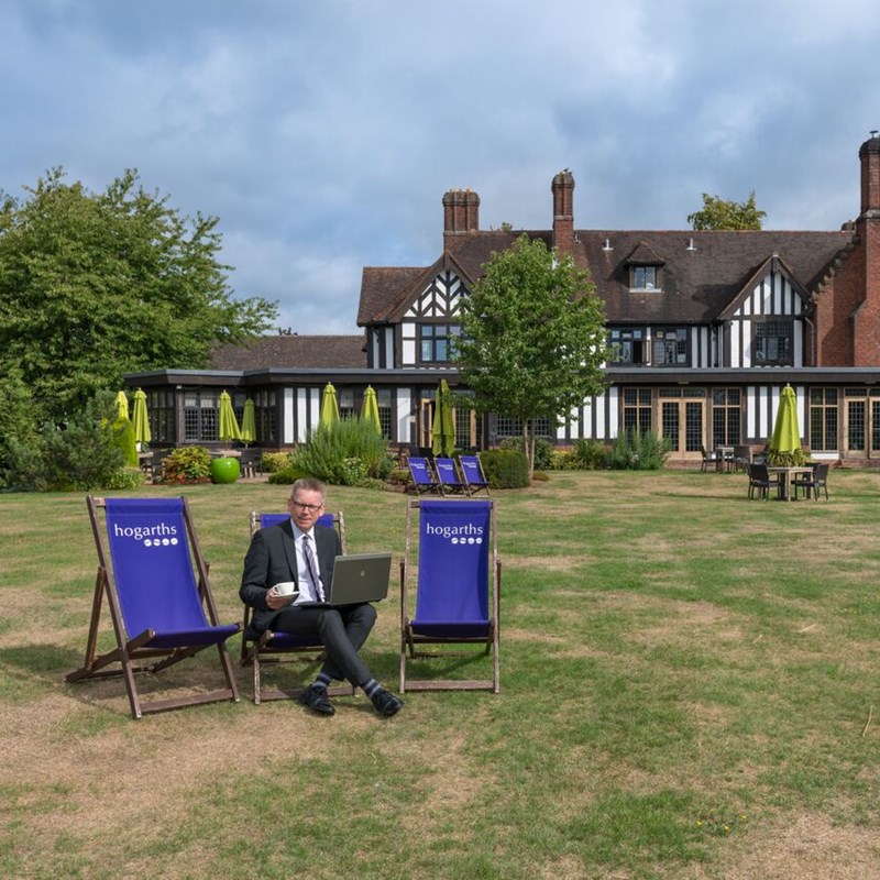 Man sat in deckchair on lawn of hotel