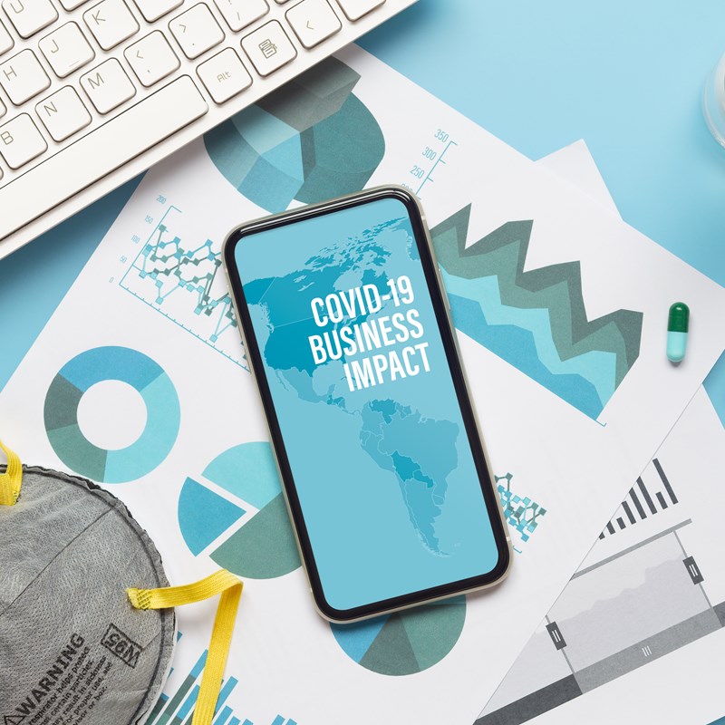 Mobile phone and keyboard with 'Business Covid impact'